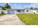 White house with blue garage door and picket fence, featuring a spacious lawn at 3529 Windham Dr, Holiday, FL 34691