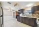 Kitchen with granite countertops, dark wood cabinets, and tile flooring at 3529 Windham Dr, Holiday, FL 34691
