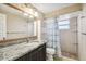 Bright bathroom featuring a granite countertop, framed mirror, and a shower with blue and white striped curtain at 3529 Windham Dr, Holiday, FL 34691
