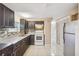 Well-lit kitchen with stainless steel appliances, granite countertops, and dark wood cabinets at 3529 Windham Dr, Holiday, FL 34691