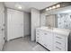 Modern bathroom with white cabinets, gray hexagon tile floor, and a large mirror at 399 2Nd St # 718, Indian Rocks Beach, FL 33785