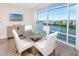 Modern dining area with water views and a round table surrounded by four white chairs at 399 2Nd St # 718, Indian Rocks Beach, FL 33785