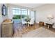 Modern dining area with a round table, four white chairs, and large windows offering water views at 399 2Nd St # 718, Indian Rocks Beach, FL 33785