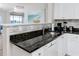 Kitchen features granite countertops and white shaker cabinets at 399 2Nd St # 718, Indian Rocks Beach, FL 33785