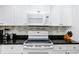 White cabinets, black countertop, and electric cooktop at 399 2Nd St # 718, Indian Rocks Beach, FL 33785