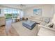Bright and airy living room with large windows, comfortable seating, and hardwood floors at 399 2Nd St # 718, Indian Rocks Beach, FL 33785