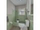 Bathroom with green tile, bathtub, toilet, and window at 775 Pennsylvania Ave, Palm Harbor, FL 34683