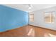 Bedroom with light wood floors and blue accent wall at 8069 Pagoda Dr, Spring Hill, FL 34606