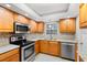 Modern kitchen with stainless steel appliances and light wood cabinets at 147 Bluff View Dr # 204, Belleair Bluffs, FL 33770