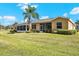 Tan house exterior with a screened porch and lush green lawn at 2493 Kensington Greens Dr # 2493, Sun City Center, FL 33573