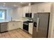 Modern kitchen featuring white cabinets, stainless steel appliances, and light tile floors at 25989 Bimini Sands Ct, Englewood, FL 34223