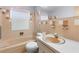 Retro bathroom with beige tile, bathtub, and sink at 4148 Arrowhead Ave, Spring Hill, FL 34606