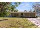 Ranch-style home with a double garage, situated on a grassy lot with mature trees at 4148 Arrowhead Ave, Spring Hill, FL 34606