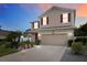 Two-story house with tan siding, red shutters, and landscaped front yard at dusk at 4160 Little Gap Loop, Ellenton, FL 34222