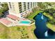 Aerial view of resort-style pool and pond with fountain, lush landscaping, and building at 501 Haben Blvd # 806, Palmetto, FL 34221