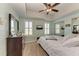 Bright bedroom with a ceiling fan, a television, two windows, and mirrored sliding closet doors at 501 Haben Blvd # 806, Palmetto, FL 34221