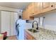 Laundry area with granite counters, a stainless sink and a modern washing machine at 501 Haben Blvd # 806, Palmetto, FL 34221