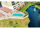 Community pool with lounge chairs, located next to pond and building at 501 Haben Blvd # 806, Palmetto, FL 34221