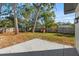 Fenced backyard with a brick fireplace, green grass, and a concrete patio at 523 Deville E Dr, Largo, FL 33771
