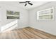 Bright bedroom with wood-look flooring and neutral walls, illuminated by natural light streaming through two windows at 523 Deville E Dr, Largo, FL 33771