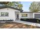 Charming one-story home features a gray roof, white paint, and manicured landscaping at 523 Deville E Dr, Largo, FL 33771