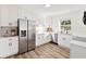 Modern kitchen featuring white cabinets, stainless steel appliances, and sleek countertops with a large fridge at 523 Deville E Dr, Largo, FL 33771