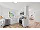 Modern, well-lit kitchen with stainless steel appliances, white cabinets, and an adjacent view into the living space at 523 Deville E Dr, Largo, FL 33771