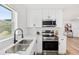 A modern kitchen boasts stainless steel appliances, white subway tile, and quartz countertops at 523 Deville E Dr, Largo, FL 33771