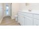 Bathroom with white vanity, toilet, shower, and door leading outside at 937 Bunker View Dr, Apollo Beach, FL 33572