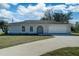 Single story home with attached garage and landscaped lawn at 11339 Gulfstream Blvd, Port Charlotte, FL 33981