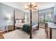 Charming bedroom featuring a four-poster bed and ample natural light at 14631 Village Glen Cir, Tampa, FL 33618