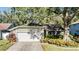 House exterior with a two-car garage and landscaping at 14631 Village Glen Cir, Tampa, FL 33618