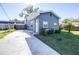 Newly renovated home with gray exterior, white door, and landscaped yard at 1512 W Kirby St, Tampa, FL 33604