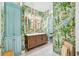 Charming bathroom featuring tropical wallpaper, double vanity, and blue cabinets at 1925 Beach Se Dr, St Petersburg, FL 33705