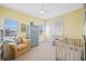 Bedroom featuring a ceiling fan, large windows, neutral carpet, chair, crib and blue dresser at 1925 Beach Se Dr, St Petersburg, FL 33705