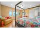 Bright bedroom with hardwood floors, four-poster bed, waterfront views, and cozy sitting area at 1925 Beach Se Dr, St Petersburg, FL 33705