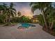Backyard with a private pool, lush landscaping, and a serene ambiance at sunset at 1925 Beach Se Dr, St Petersburg, FL 33705