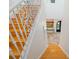 Elegant staircase with wooden steps and decorative wrought iron railing leads to a bright foyer with tiled floors at 1925 Beach Se Dr, St Petersburg, FL 33705