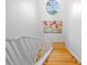 Bright staircase featuring wooden steps and decorative railing leads to a landing with colorful artwork and a circular window at 1925 Beach Se Dr, St Petersburg, FL 33705