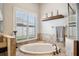 Relaxing bathroom with a large soaking tub and window at 27200 Hawks Nest Cir, Wesley Chapel, FL 33544