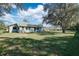 Large backyard with mature trees and grassy area at 2733 Cranbrook Ave, North Port, FL 34286