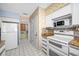 Kitchen with white appliances and granite countertops at 2801 Gulf Blvd, Belleair Beach, FL 33786