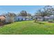 Spacious backyard with lush lawn, play set, and partial view of the home's exterior at 3407 King George Ln, Seffner, FL 33584