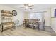 Bright dining room with wood-look flooring, a ceiling fan, large window, and a dining table with seating for six at 3407 King George Ln, Seffner, FL 33584