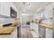Galley kitchen featuring butcher block countertops, stainless steel appliances, white cabinets, and wood-look flooring at 3407 King George Ln, Seffner, FL 33584