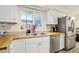 Bright kitchen with butcher block counters, stainless steel sink, stainless steel refrigerator and a white tile backsplash at 3407 King George Ln, Seffner, FL 33584