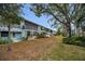 Exterior view of condominium units with private patios overlooking the expansive, well-maintained backyard at 4152 55 N Way # 1030, Kenneth City, FL 33709