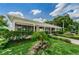 Exterior view of a community center with lush landscaping and palm trees at 4152 55 N Way # 1030, Kenneth City, FL 33709