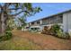 Exterior view of a multi-unit building with grassy yard and trees at 4152 55 N Way # 1030, Kenneth City, FL 33709