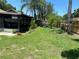Expansive backyard with lush green grass and a screened-in lanai for outdoor living at 5105 Garden Vale Ave, Tampa, FL 33624